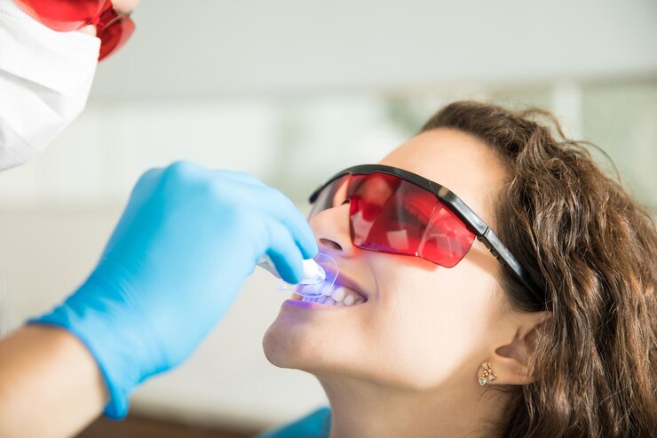 closeup-young-woman-having-her-teeth-whitened-with-ultraviolet-light-dental-clinic_662251-2598 Closeup of young woman having her teeth whitened with ultraviolet light in a dental clinic<br />