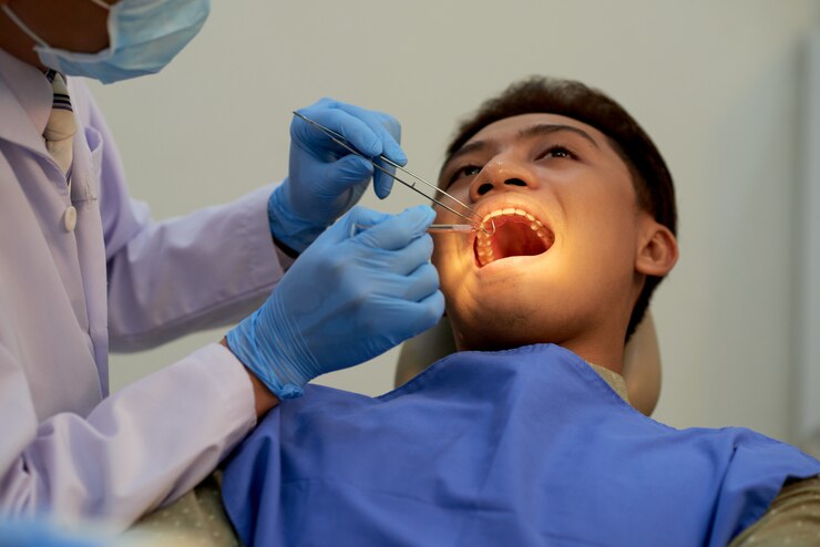 young-man-sitting-mouth-wide-open-office-dentist-annual-examination_1098-20340 Young man sitting mouth wide open at the office of dentist at the annual examination<br />